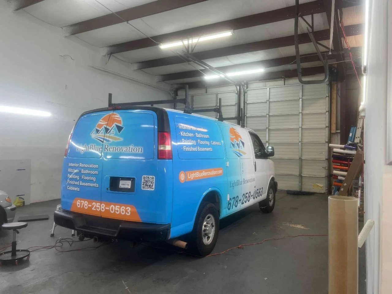 Blue commercial service van with white and orange graphics