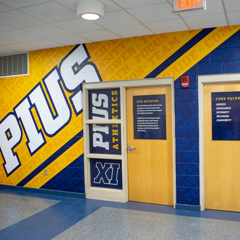 Bold blue and yellow Pitts Athletics school wall wrap